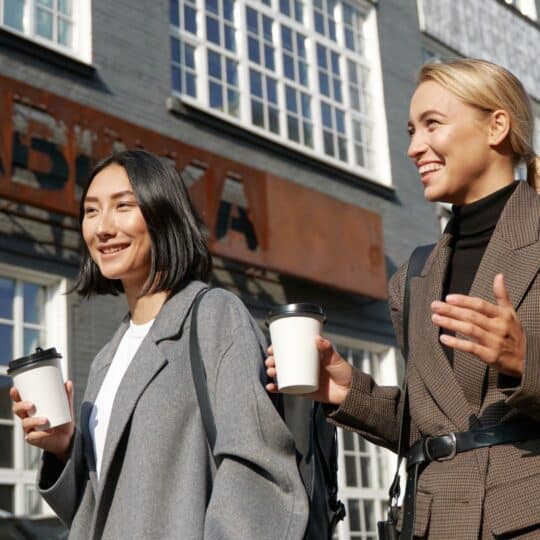 women walking drinking coffee while doing the coffee walk challenge